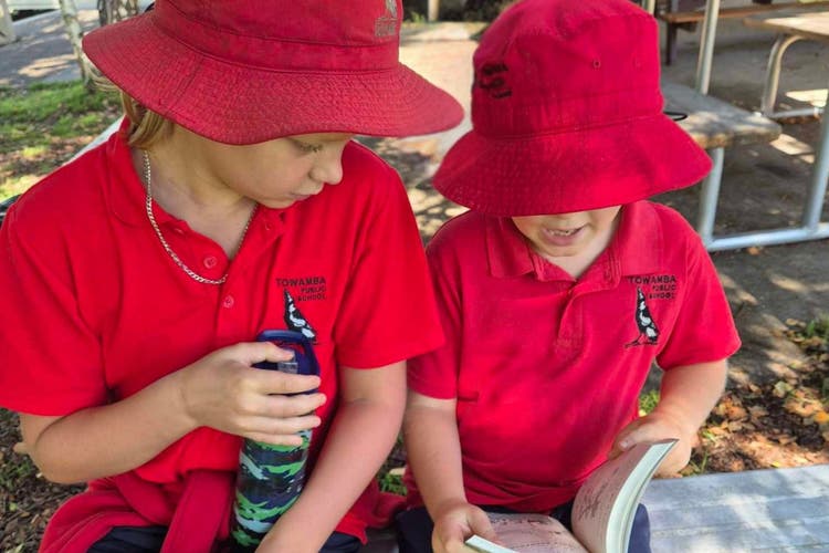 Older student mentoring younger student reading